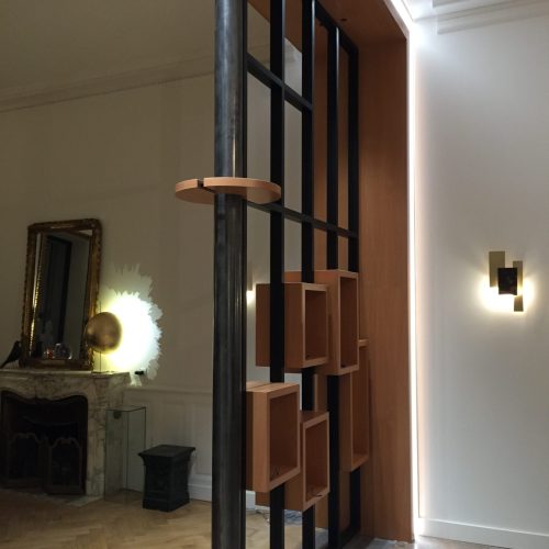 Séparation d’espace élégante combinant bois naturel et montants métalliques noirs